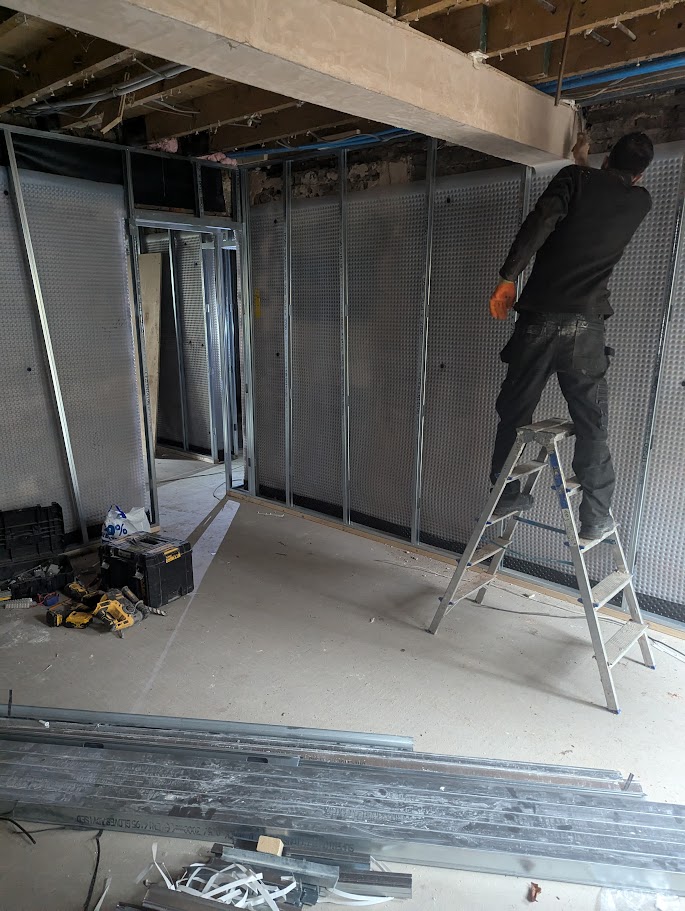 Contractors installing a metal stud partition wall as part of a commercial drylining project in Sheffield