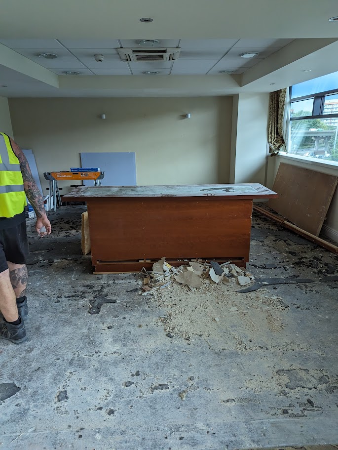 Contractors removing commercial flooring as part of an end of lease dilapidations project