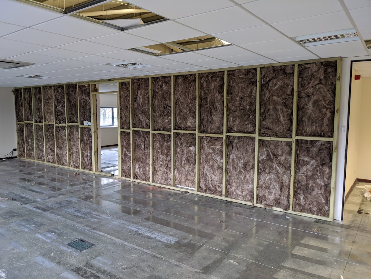 Insulated internal partition wall being installed for sound reduction and thermal performance