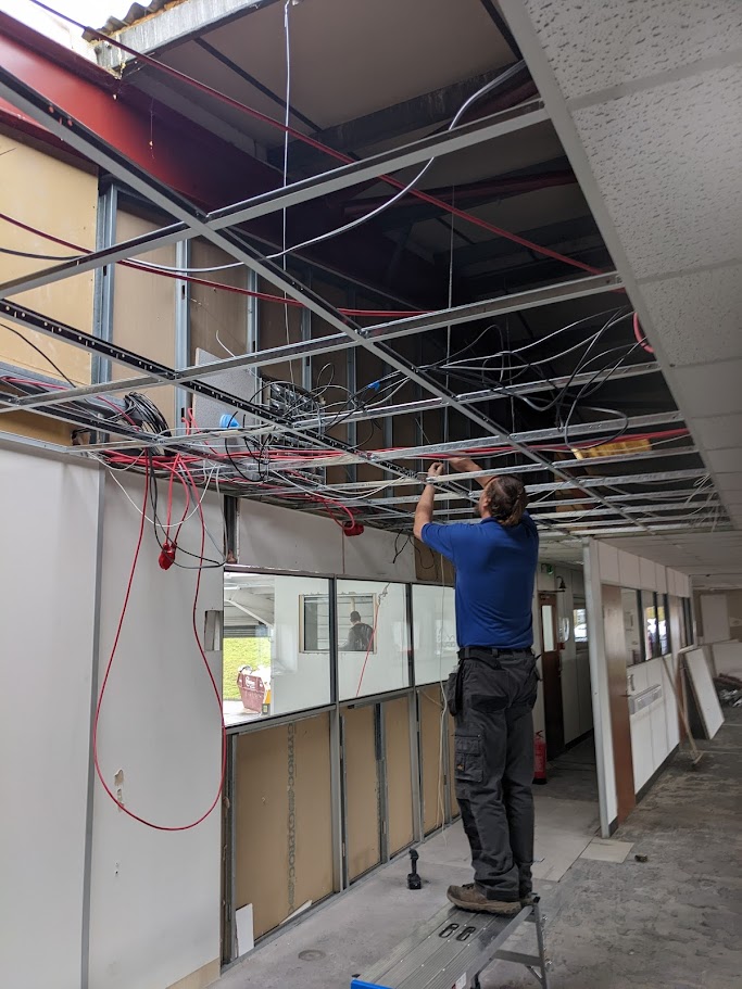 Contractors installing a suspended ceiling grid system during a commercial interior refurbishment
