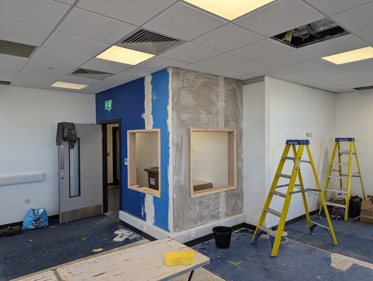 Contractors applying wall finishes during a commercial interior refurbishment