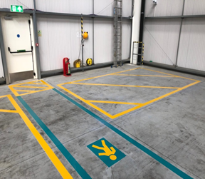 Factory floor safety markings showing pedestrian routes and hazard zones