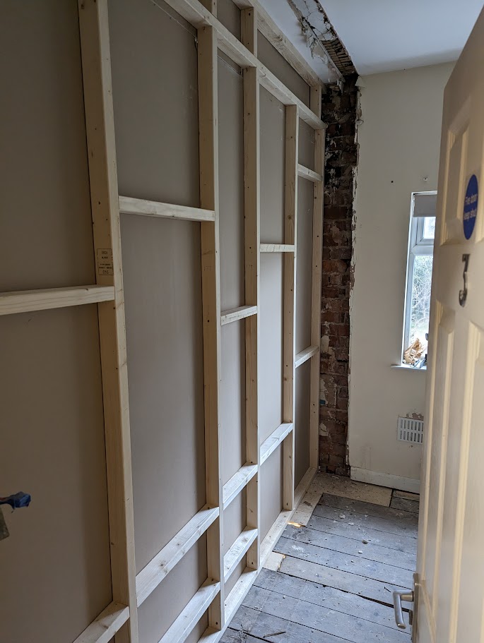 Drylining contractors installing plasterboard partition walls inside a commercial building