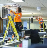 Commercial electrician installing wiring and lighting systems